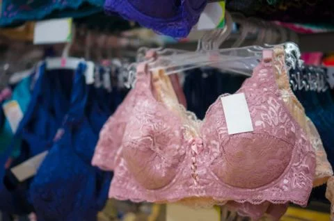 Various light brown and dark blue lace bras on stand in store Foto stock