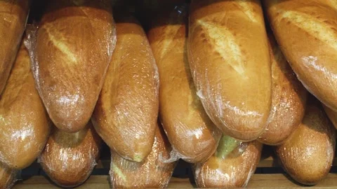 Various loaves of bread types in plastic package on shelf in supermarket Stock Footage 151101046