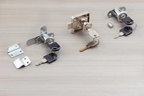 Various locks and keys placed on a light gray surface, showing different ty.. Stock Photos