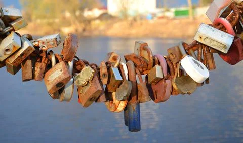 Various locks hang from chains. Stock Photos