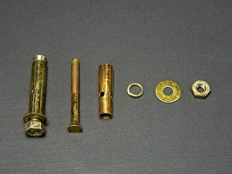 Various loose gold hardware items are neatly arranged on a dark gray textur.. Stock Photos