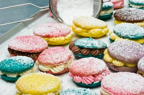 Various macaroons dusted with icing sugar on a baking tray Stock Photos