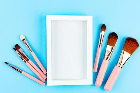 Various Makeup Brushes on blue Background Photos