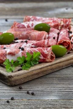 Various meats on serving board with rustic background Stock Photos