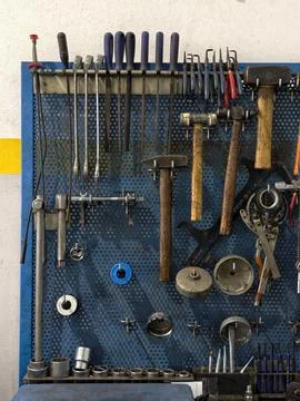 Various mechanic hand tools organized on a blue perforated pegboard Stock Photos