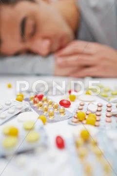 Various medicine in blisters and sleeping guy on background Stock Photos