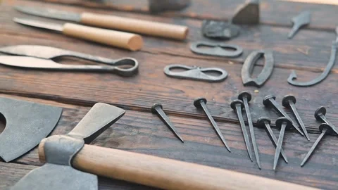 Various medieval tools and equipment are arranged on a wooden table in a Видео 345030945