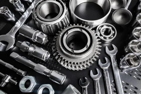 Various metallic tools and mechanical components arranged neatly on a black Stock Photos