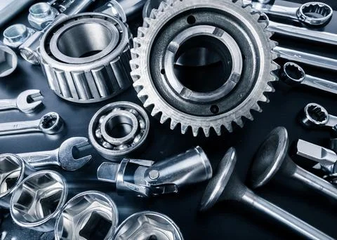Various metallic tools and mechanical parts arranged on a dark surface for Stock Photos