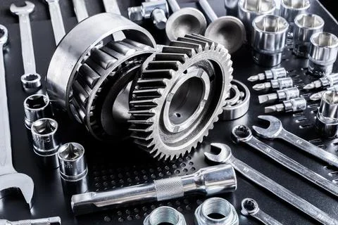 Various metallic tools and mechanical parts arranged on a dark surface Stock Photos