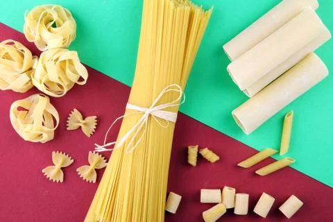 Various mix of pasta flat lay on colored paper. Diet and food concept. Stock Photos
