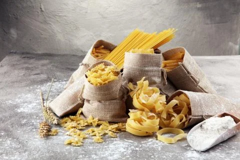 Various mix of pasta on grey rustic background. Diet and food concept. Stock Photos