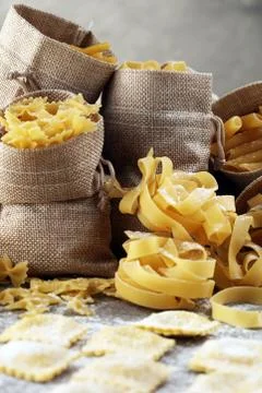 Various mix of pasta on grey rustic background. Diet and food concept. Stock Photos