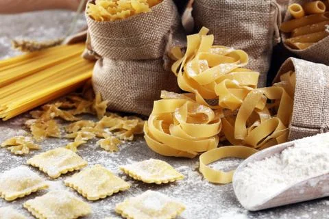 Various mix of pasta on grey rustic background. Diet and food concept. Stock Photos