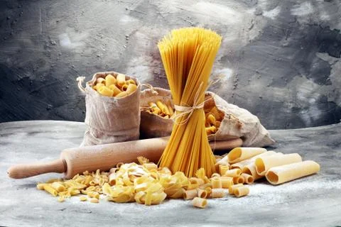 Various mix of pasta on grey rustic background. Diet and food concept. Stock Photos
