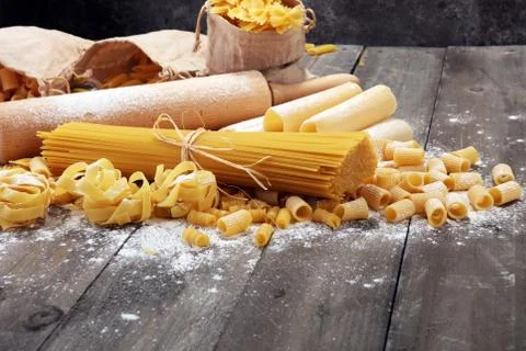 Various mix of pasta on grey rustic background. Diet and food concept. Stock Photos