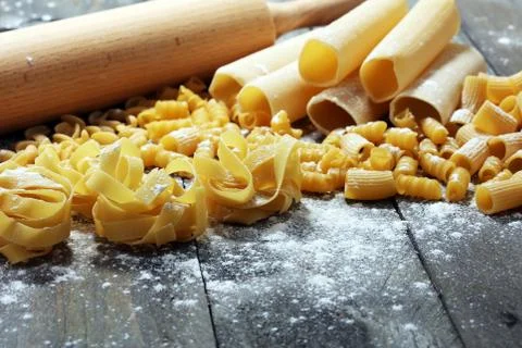 Various mix of pasta on grey rustic background. Diet and food concept. Stock Photos