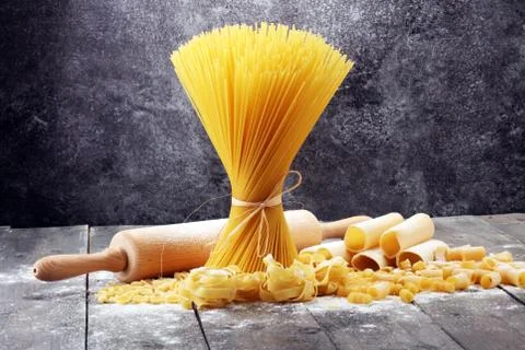 Various mix of pasta on grey rustic background. Diet and food concept. Stock Photos