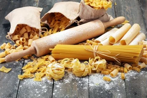 Various mix of pasta on grey rustic background. Diet and food concept. Stock Photos