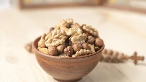 Various nuts in clay cup on table in front of Orthodox icon. Food for Christians Stock Photos