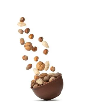 Various nuts falling into a cup isolated on white background Stock Photos