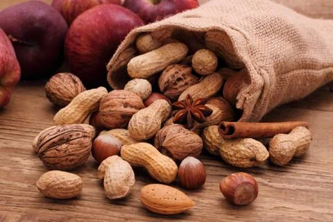 Various nuts in jute sack cinnamon sticks, star anise Stock Photos