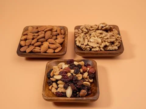 Various nuts on an orange background. Mixed nuts. Stock Photos