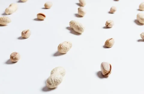 Various nuts: pistachio and shell peanuts repetition on white background as Stock Photos