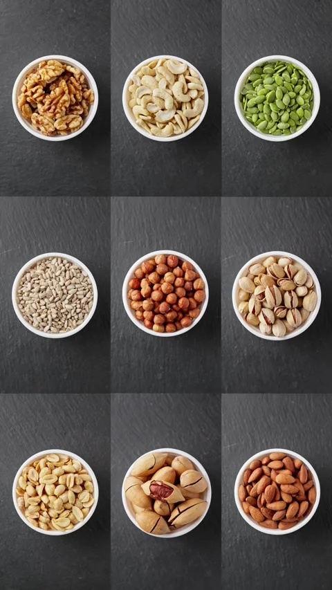Various nuts rotating at dark background. Different snacks in white bowl. Video stock 294923266