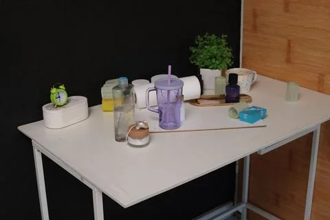 Various objects arranged on a white table against a dark background Stock Photos