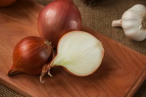 Various onions on a board on a background sacking, burlap Foto stock