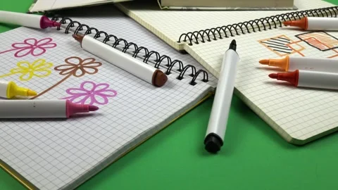 Various open notepads with notations on the pages lie on a green background Stock Footage 336507459