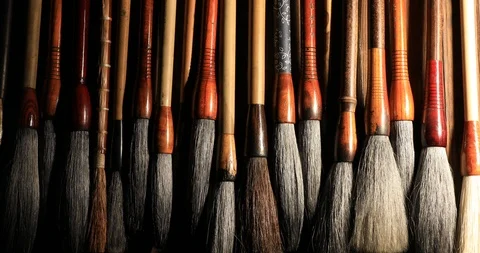 Various oriental paintbrushes hanging on rack Video stock 92000746