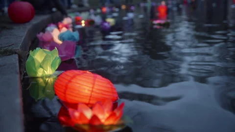 Various paper lanterns floating on river water during festival Video stock 249301301