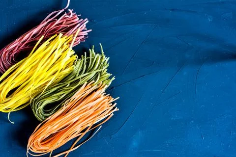 Various pasta over colored background. Top view with copy space Stock Photos
