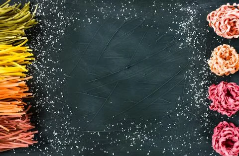 Various pasta over colored background. Top view with copy space Stock Photos