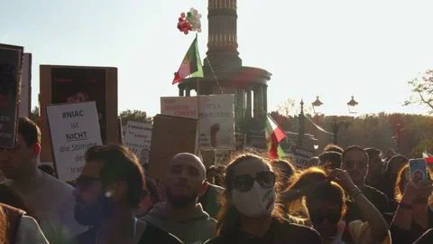 Various people with flags and slogans on banners on gathering for Iran. Huge Stock Footage 219749887