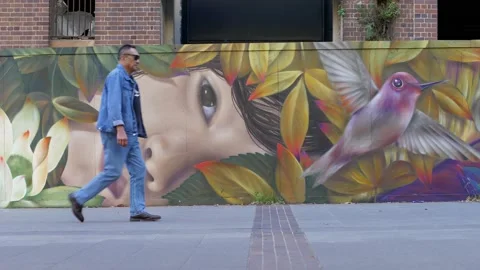 Various people pass and Graffiti face and bird 4K Video stock 153949233