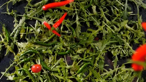 Various peppers and red cherry tomatoes fall on green leaves Stock Footage 127214903