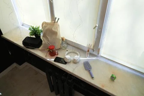 Various personal items arranged on a windowsill with natural light and deco.. Foto stock