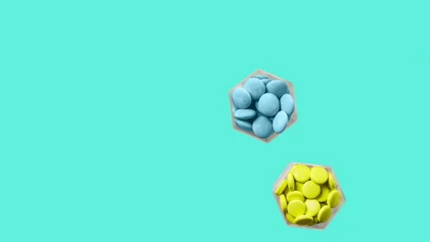 Various pills and capsules in hexagonal jars appear on a green background Stock Footage 143667643