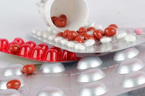Various pills are lying in bulk on the table Stock Photos