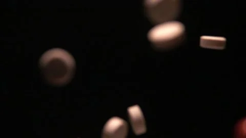 Various pills falling on a black background in slow motion Video stock 254520075