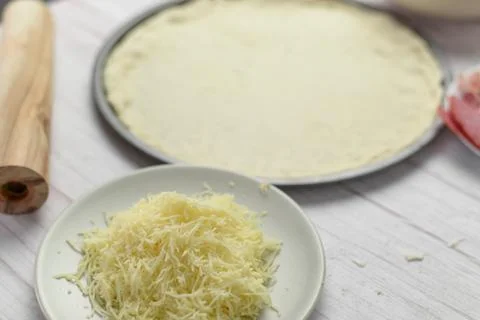Various pizza components surrounding the pizza dough foundation Stock Photos