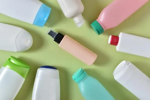 Various plastic bottles scattered on a light green background Stock Photos