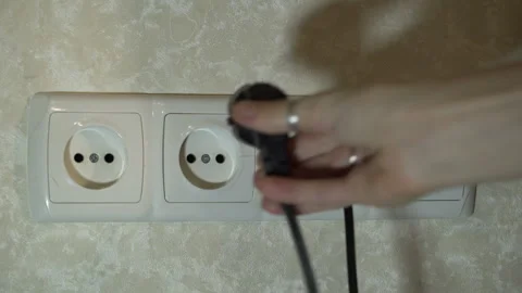 Various plugs of electrical appliances are inserted connected sockets in turn Stock Footage 256056552