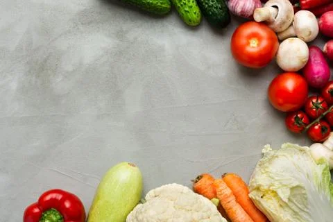 Various raw vegetables on a gray background with copy space laid out in a cir Foto stock