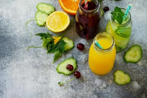 Various refreshments drinks - detox cucumber water, cherry juice. Stock Photos