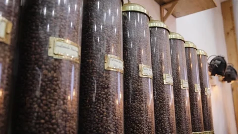 Various roasted coffee beans types in decorative glass tubes on wooden stand on Stock Footage 170611585
