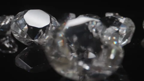 Various round classic diamonds on reflective black surface shiny stones Stock Footage 225940892